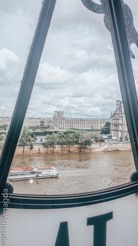 Widok na Luwr zza zegara w Muzeum Orsay